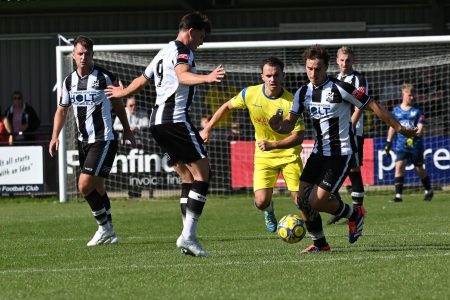 picture of football match on a sunny day and Wimborne Town Football Club logo
