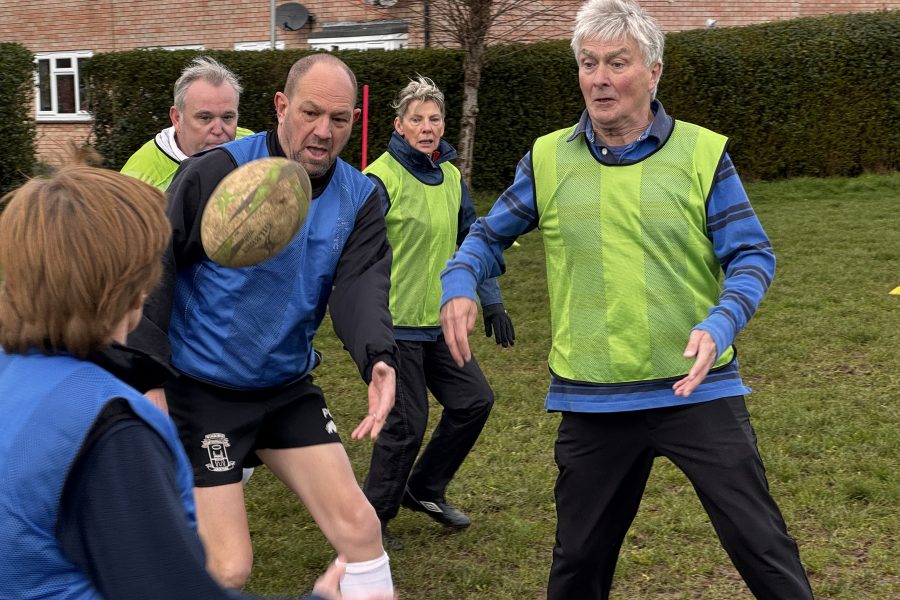 Group of walking rugby players involved in a game. Plus Wimborne Rugby Club logo