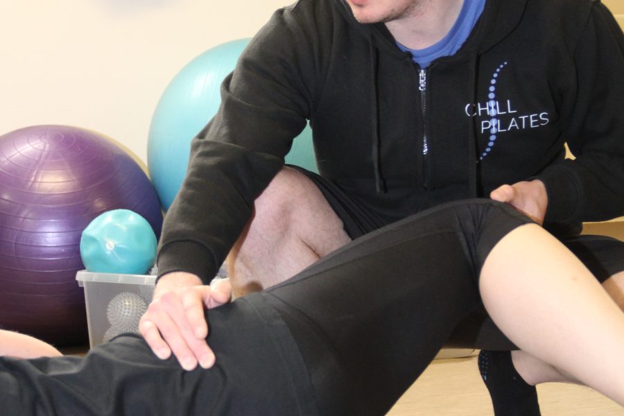 Chillpilates logo and photograph of instructor showing participant how to do an exercise.