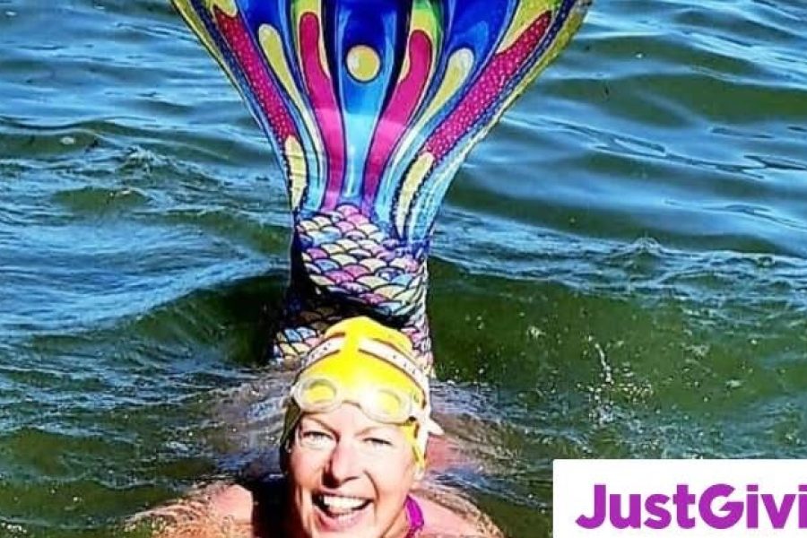 A photo of a woman in the sea wearing a mermaid tail swimming in aid of charity